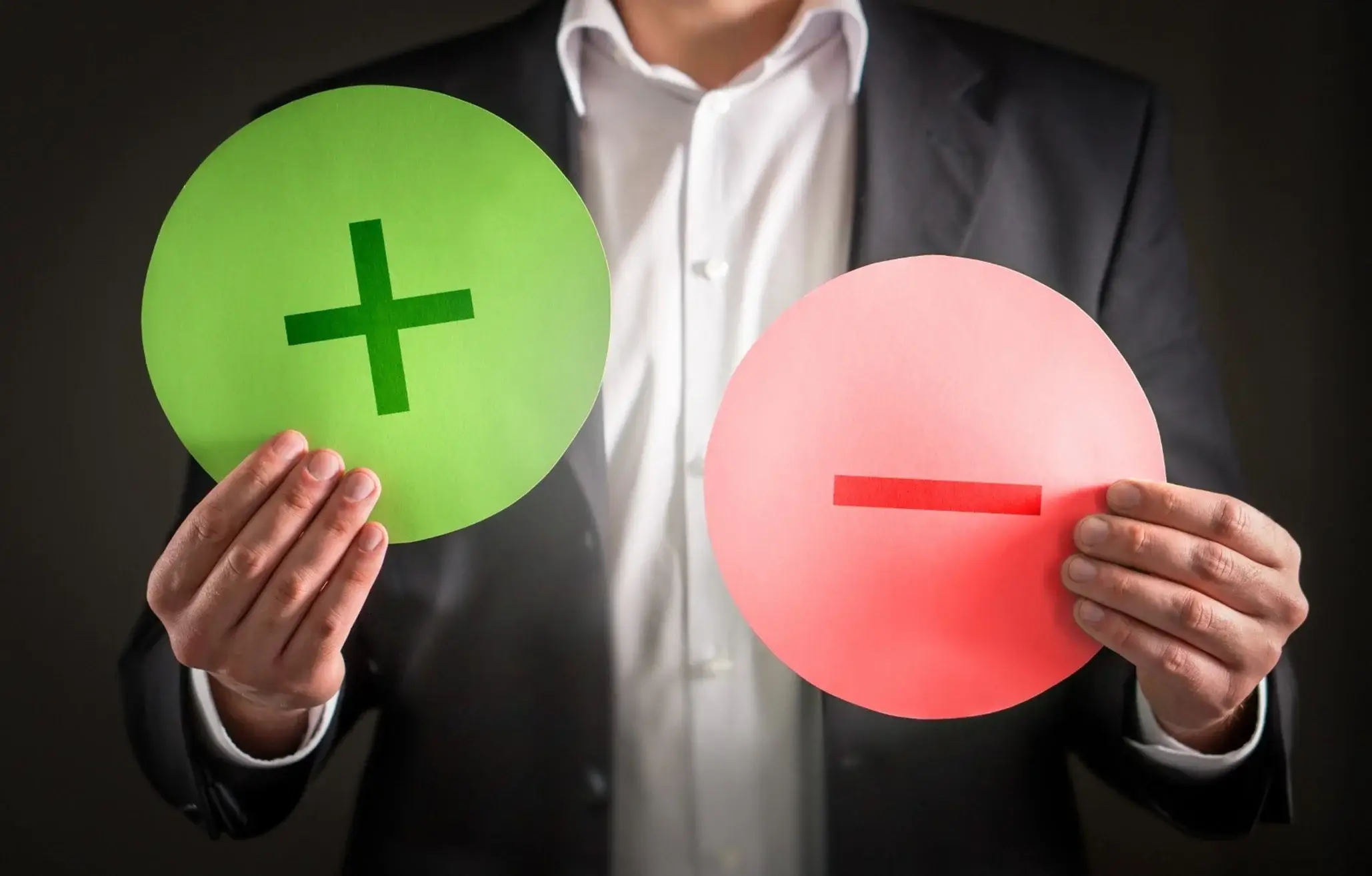 Artı ve eksi fotoraflarını tutan adam